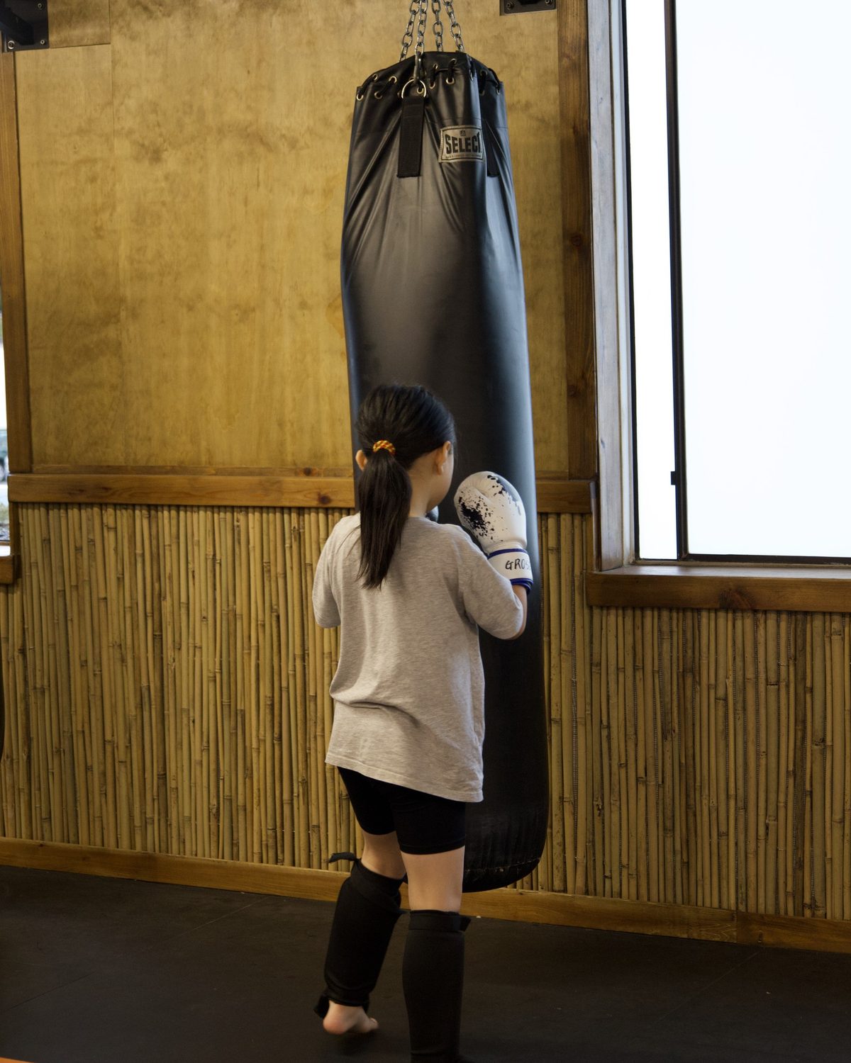 A child working on punches at the heavy bag at Kingdom Athletics