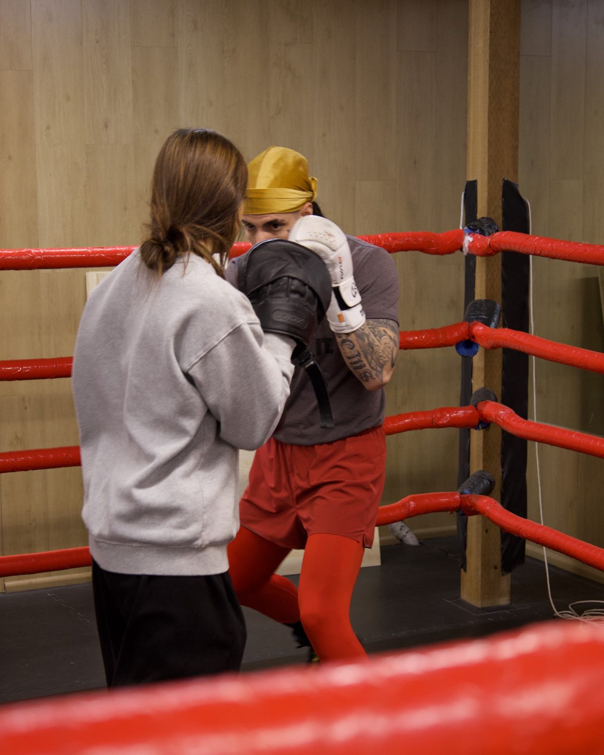 A coach holding pads for a boxer in the ring, boxing classes langley at Kingdom Athletics