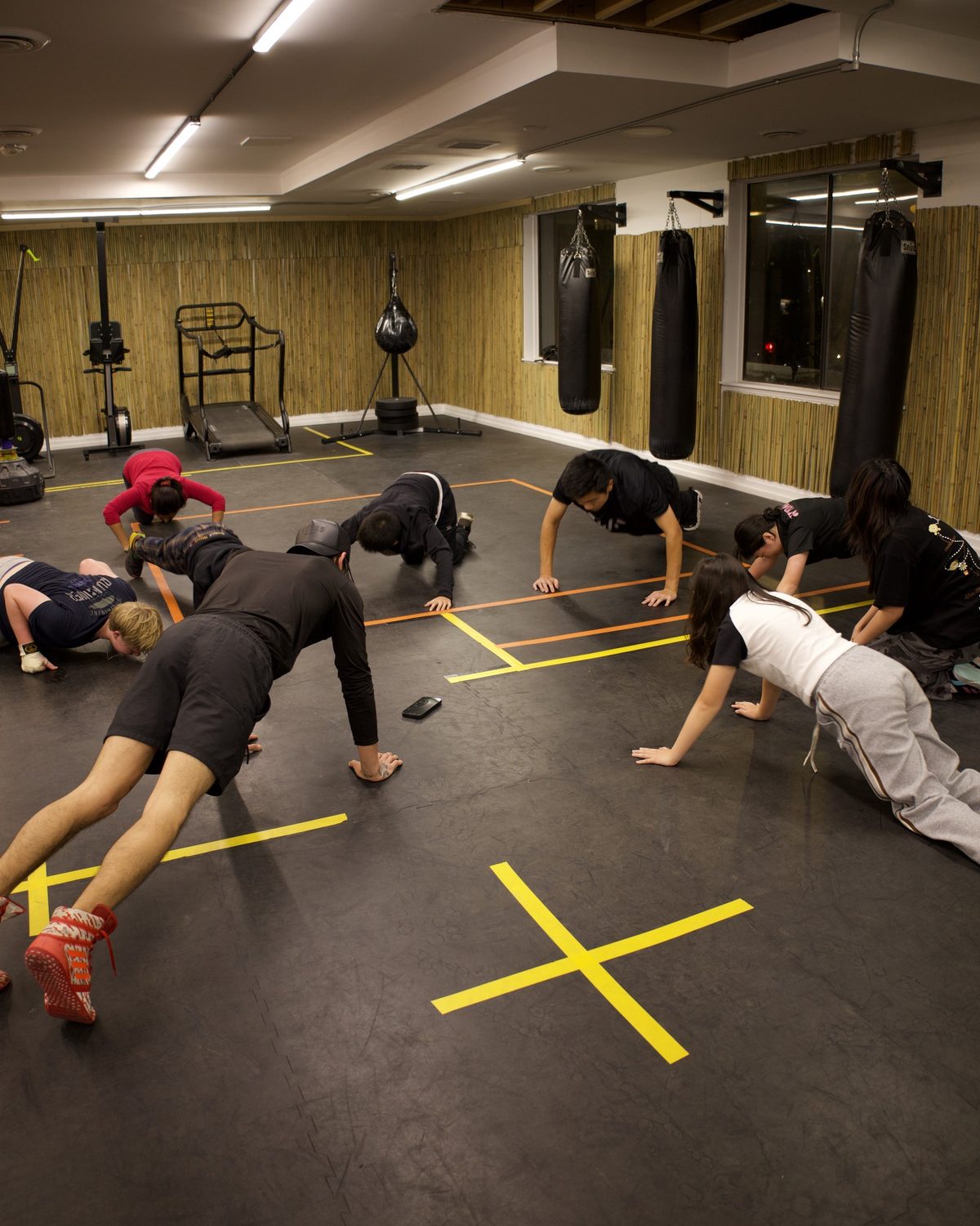 A group class doing push-ups and bodyweight work on the gym floor at Kingdom Athletics