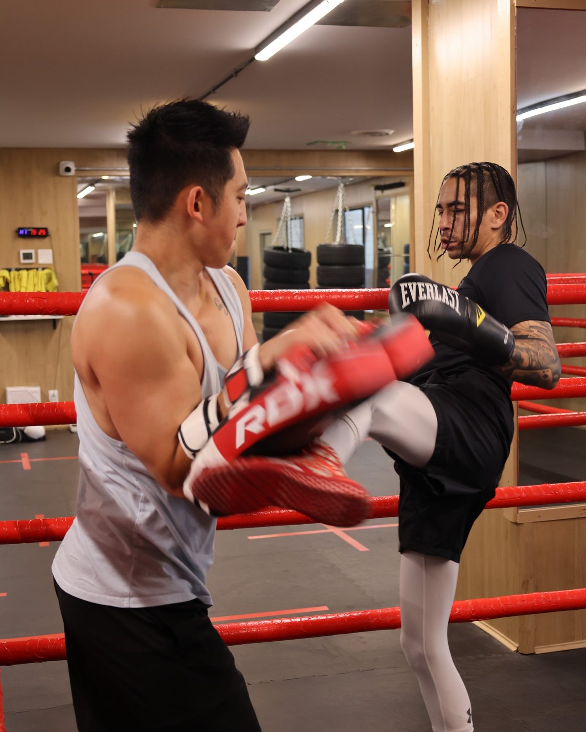 A coach catching a roundhouse kick on Thai pads, kickboxing surrey at Kingdom Athletics