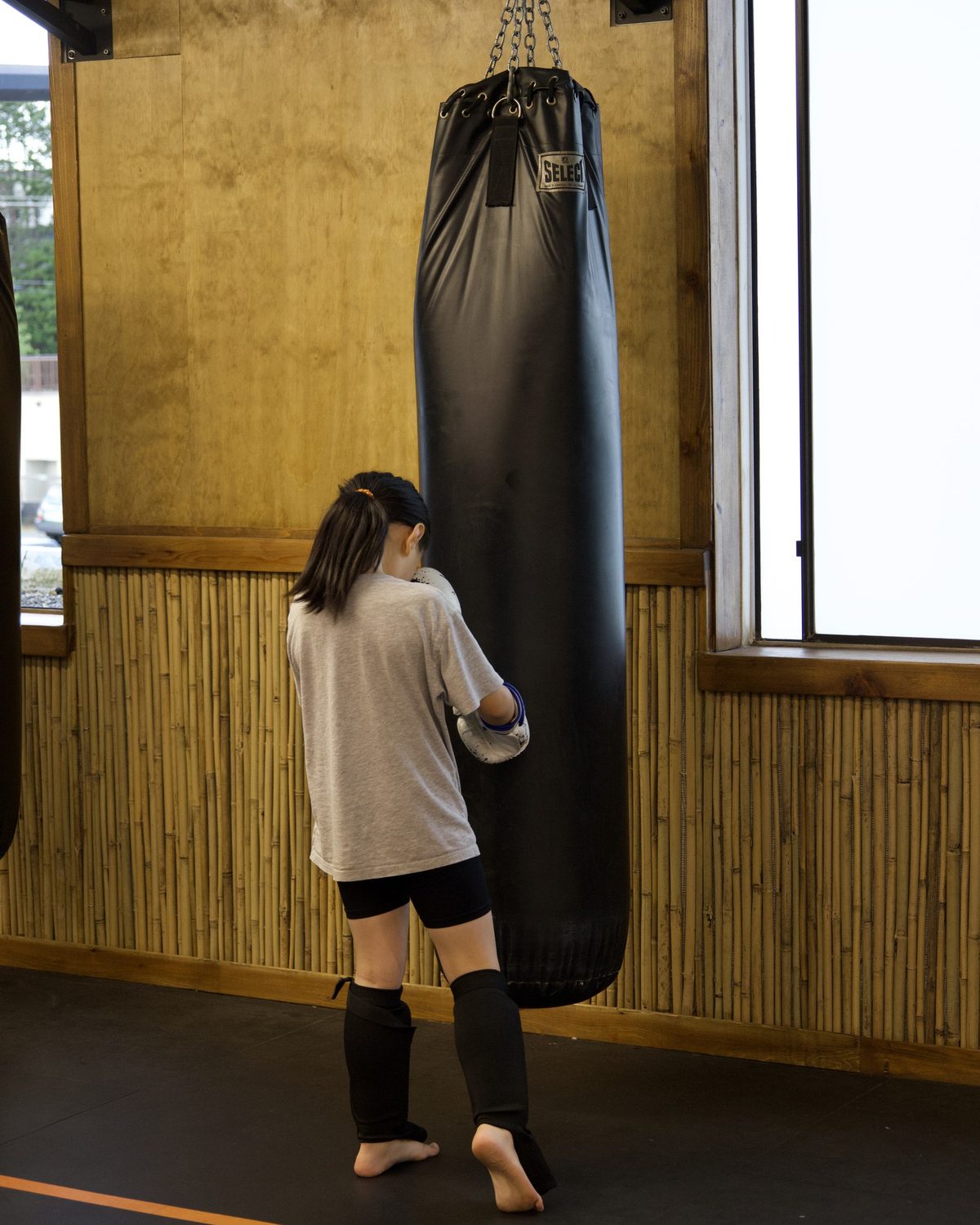 A child practising punches on the heavy bag in a kids class at Kingdom Athletics