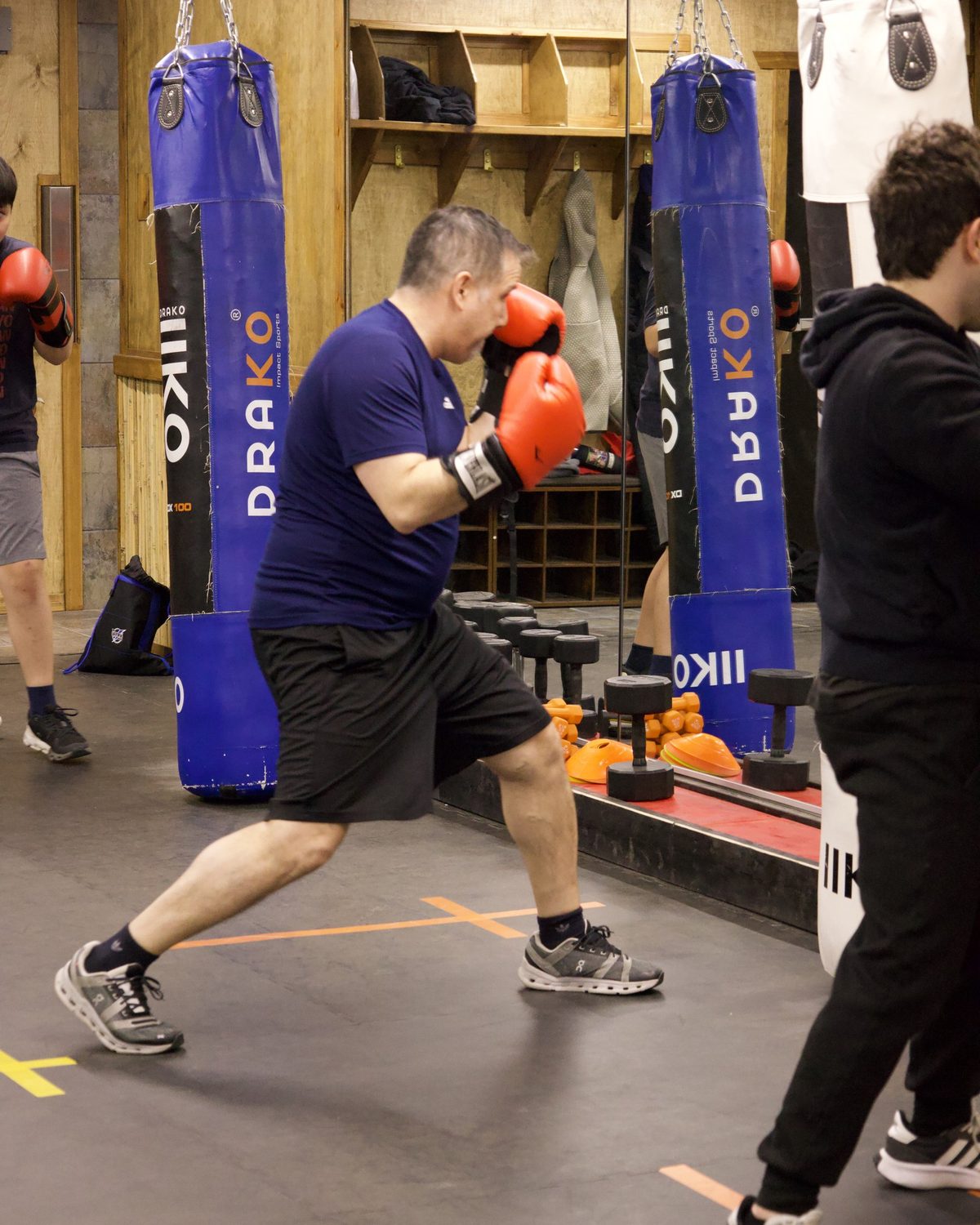 Adults hitting heavy bags during a conditioning class, weight loss gym white rock at Kingdom Athletics